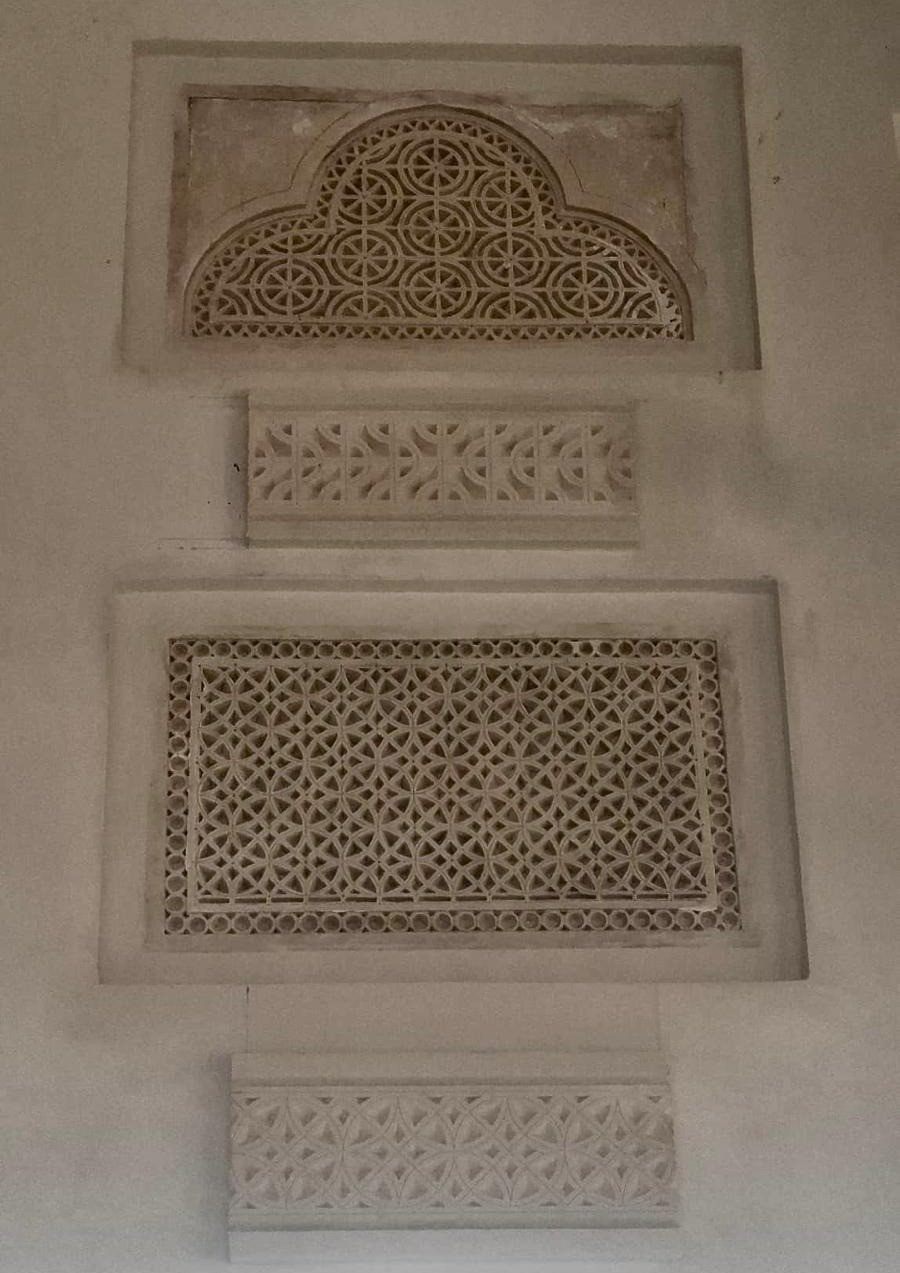 Gypsum panels, bands and an arched screen installed on a plaster wall