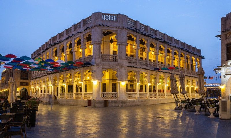 Souq Waqif at dusk, arcaded facades lit from within